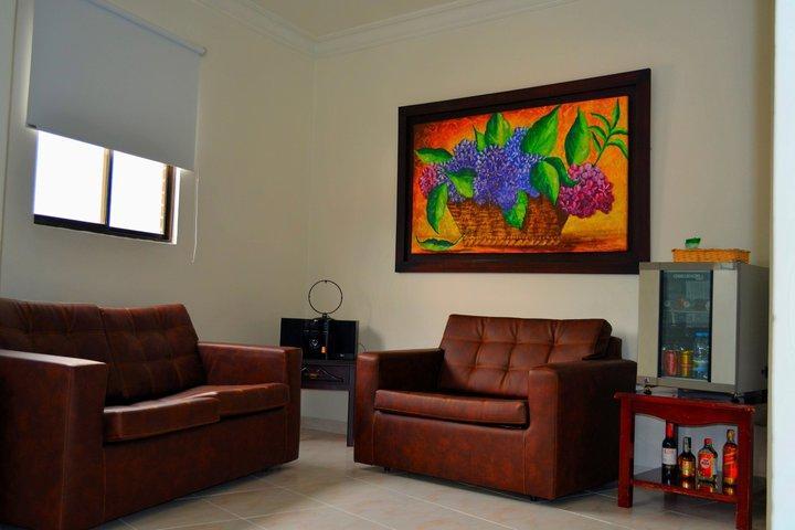Casa Morales Hotel Internacional Y Centro De Convenciones Ibagué Kültér fotó A living room with a sofa and armchair